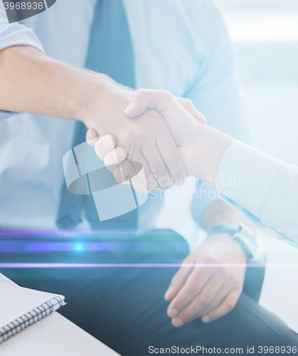 Image of businessmen shaking hands in office