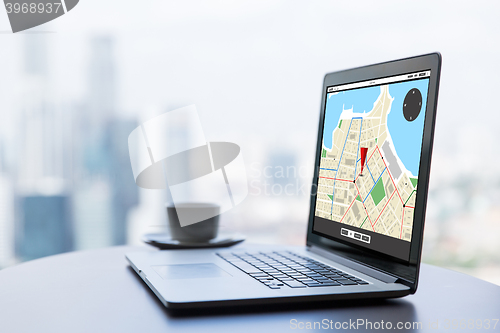 Image of close up of laptop and coffee cup on office table