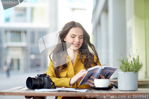 Image of happy woman with guide drinking cocoa at city cafe