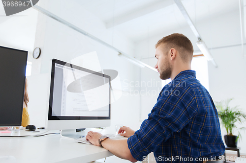 Image of creative man or programmer with computer at office