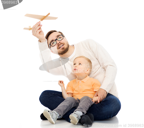 Image of father and little son playing with toy airplane