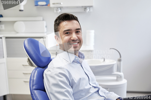 Image of happy male patient sitting on dental chair