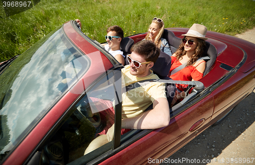 Image of happy friends driving in cabriolet car