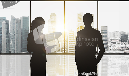 Image of silhouettes of business partners over city office