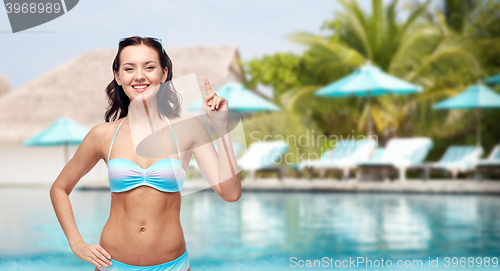 Image of happy woman in bikini swimsuit pointing finger up