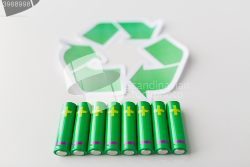 Image of close up of batteries and green recycling symbol