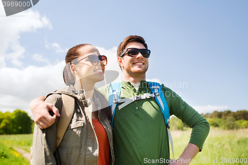 Image of happy couple with backpacks hiking outdoors