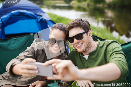 Image of couple of travelers taking selfie by smartphone