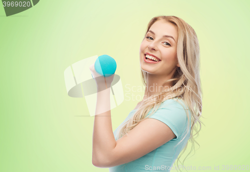 Image of smiling beautiful young sporty woman with dumbbell