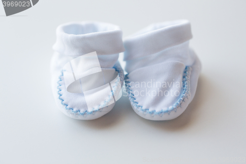 Image of close up of white baby bootees for newborn boy