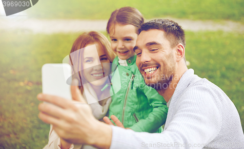 Image of happy family taking selfie by smartphone outdoors