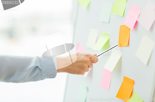 Image of close up of hand pointing to sticker on flip chart