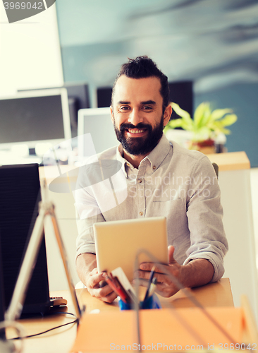 Image of happy creative male office worker with tablet pc