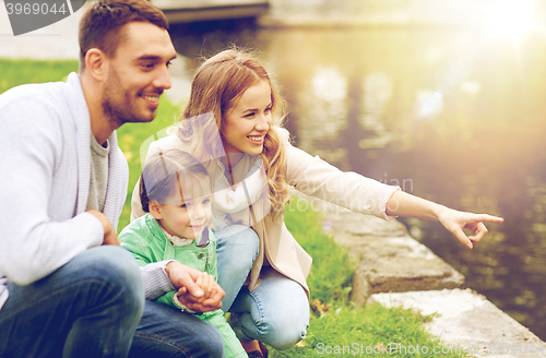 Image of happy family walking in summer park