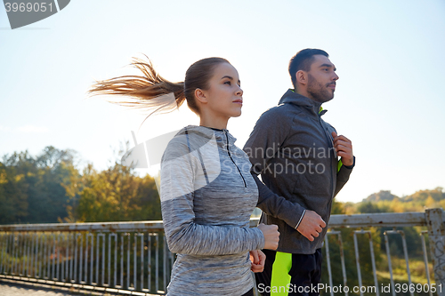 Image of happy couple running outdoors