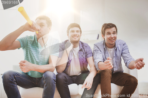 Image of happy male friends with vuvuzela