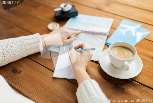 Image of close up of traveler hands with notepad and pencil