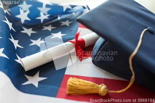 Image of bachelor hat and diploma on american flag