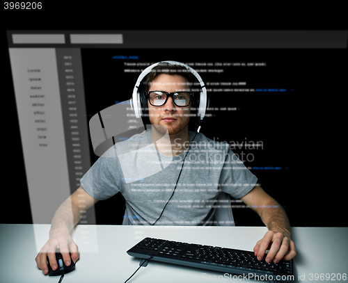 Image of man in headset hacking computer or programming