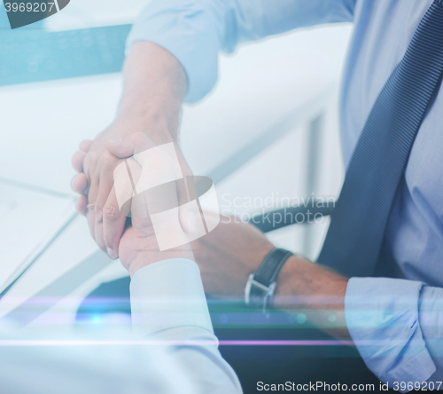 Image of businessmen shaking hands in office