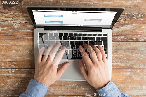 Image of close up of male hands with laptop typing