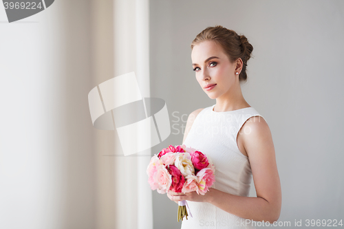 Image of bride or woman in white dress with flower bunch