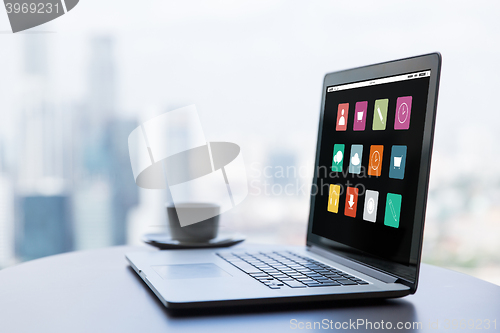 Image of close up of laptop and coffee cup on office table