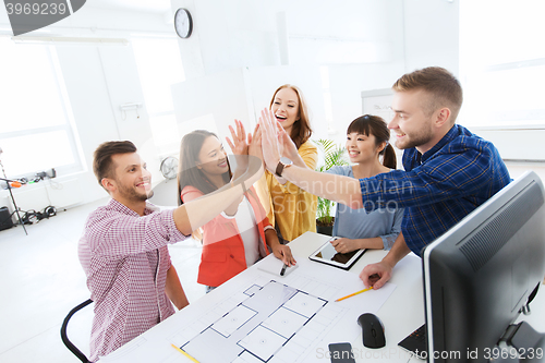 Image of creative team making high five at office