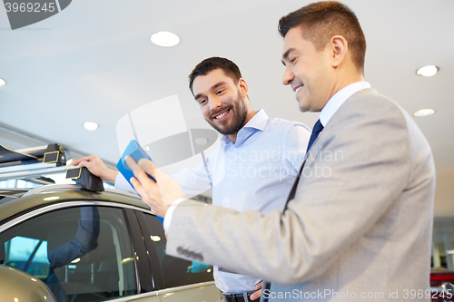 Image of happy man with car dealer in auto show or salon