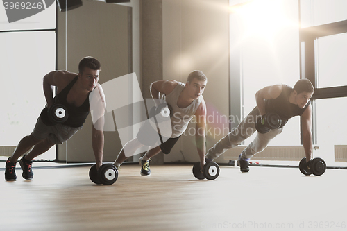 Image of group of men with dumbbells in gym