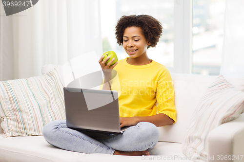 Image of happy african american woman with laptop at home