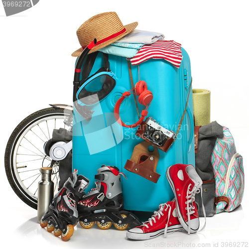 Image of The blue suitcase, sneakers, clothing, hat, and retro camera on white background.