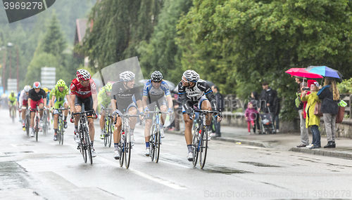 Image of Group of Cyclists Riding in the Rain - Tour de France 2014