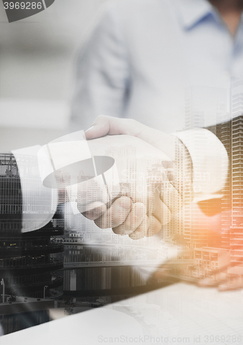 Image of two businessmen shaking hands in office