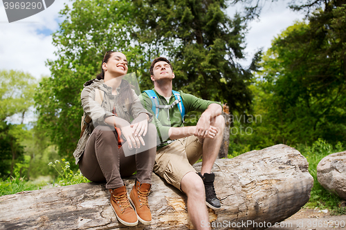 Image of smiling couple with backpacks in nature