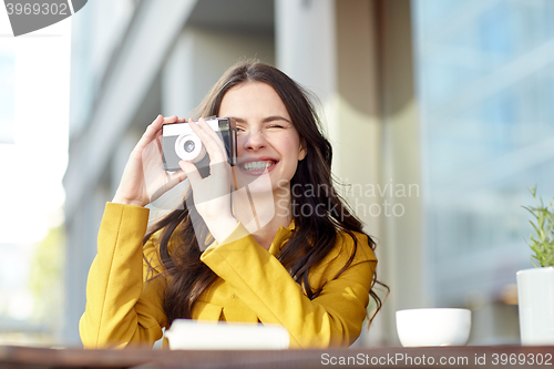 Image of happy tourist woman with camera at city cafe