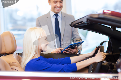 Image of happy woman with car dealer in auto show or salon