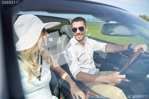 Image of happy man and woman driving in cabriolet car