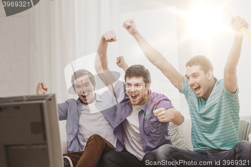 Image of happy male friends with vuvuzela watching sports