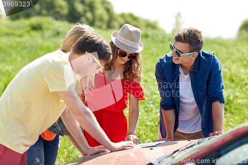 Image of happy friends with map and car searching location