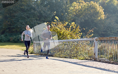 Image of happy couple running outdoors