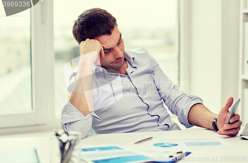 Image of  businessman with smartphone  at office 