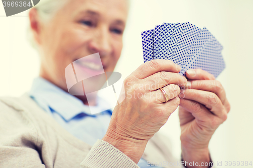 Image of close up of happy senior woman playing cards