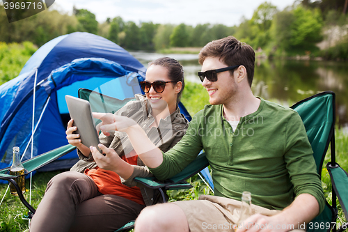 Image of happy couple with tablet pc at camping tent