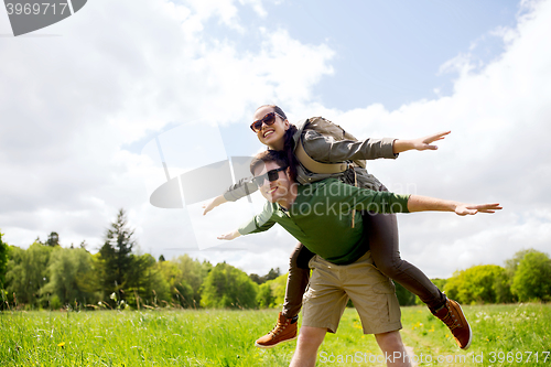 Image of happy couple with backpacks having fun outdoors