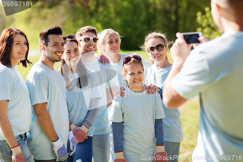 Image of group of volunteers taking picture by smartphone