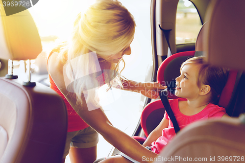 Image of happy mother fastening child with car seat belt