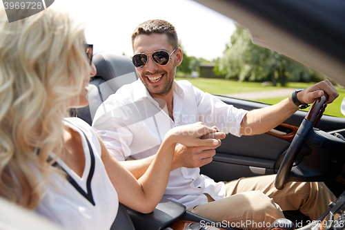 Image of happy man and woman driving in cabriolet car