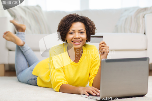 Image of happy african woman with laptop and credit card