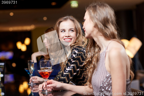 Image of happy women with drinks at night club